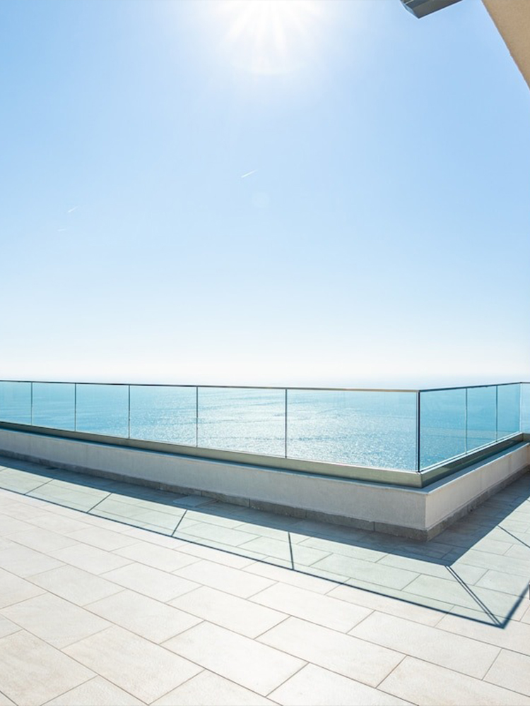 Three construction workers applying bright light blue waterproof coating on outdoor balcony